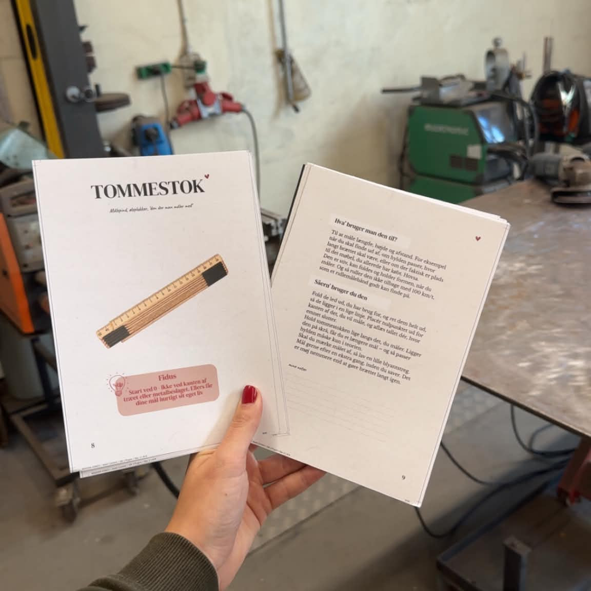 Siden om tommestokken med illustration og en fidus, holdt op i et værksted ved siden af en side med forklaring